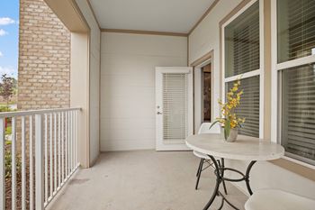 A balcony with a table and chairs and a door